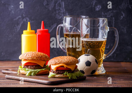 Image de deux hamburgers, lunettes, ballon de soccer, ketchup Banque D'Images