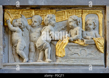 Bas-relief en pierre et d'or de chérubins dans un atelier textile, trouvés sur la façade d'une maison médiévale sur la Grand Place de Bruxelles Banque D'Images