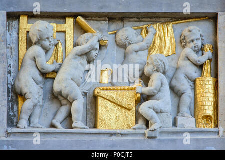 Bas-relief en pierre et d'or de chérubins dans un atelier textile, trouvés sur la façade d'une maison médiévale sur la Grand Place de Bruxelles Banque D'Images