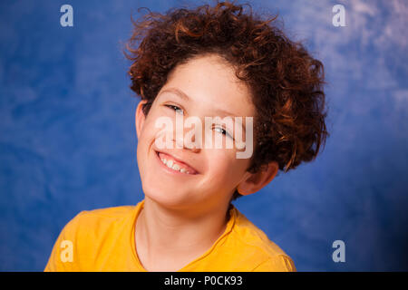 Close-up of preteen curly boy smiling and looking at camera Banque D'Images