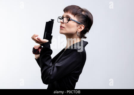 Un portrait d'une belle femme avec de l'agent sous couvert de poing sur fond blanc avec l'exemplaire de l'espace. Banque D'Images