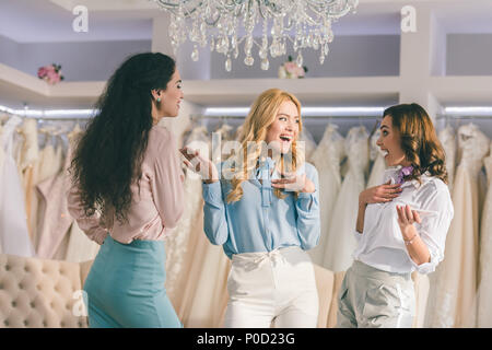 Les jeunes femmes s'amusant à wedding fashion shop Banque D'Images