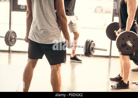 Cropped shot of young men in sport sportswear levée barbells in gym Banque D'Images