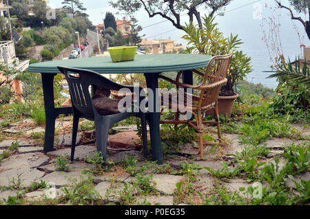 Chat assis sur chaise à Pieve Ligure, village italien sur la mer. Belle vue depuis le jardin. Banque D'Images