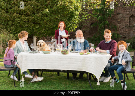 Grande famille en train de dîner ensemble à campagne Banque D'Images