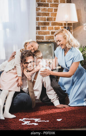 Happy Family hugging vintage tout en jouant aux dominos à la maison Banque D'Images