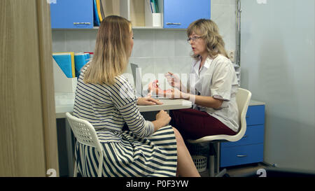 Médecin gynécologue consulting female patient à l'aide d'utérus anatomy model Banque D'Images