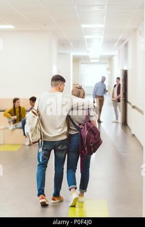 Vue arrière d'étudiants adolescents couple walking par couloir d'école et l'adoption Banque D'Images