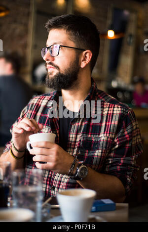 Hipster barbu homme dans un café-bar Banque D'Images