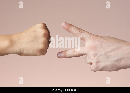 Roche, papier et ciseaux jeu main theme. Jeu de mains close-up isolé sur fond brun Banque D'Images