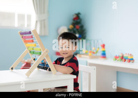 Bébé garçon enfant asiatique apprend à compter. Mignon enfant jouant avec abacus jouet. Petit garçon s'amusant à l'intérieur à la maison. Concept éducatif pour tout-petit bab Banque D'Images