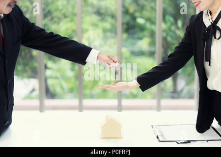 Agent immobilier en donnant les clés de propriétaire de l'appartement, l'achat vente de biens d'affaires. Close up of woman hand taking clé de la maison de l'immobilier. Pour les prêts hypothécaires Banque D'Images