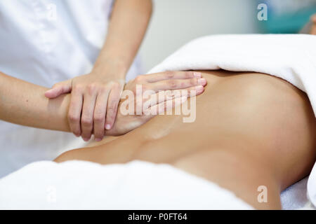 Abdomen femelle massage mains.Thérapeute en appliquant une pression sur le ventre. Woman receiving massage at spa salon Banque D'Images