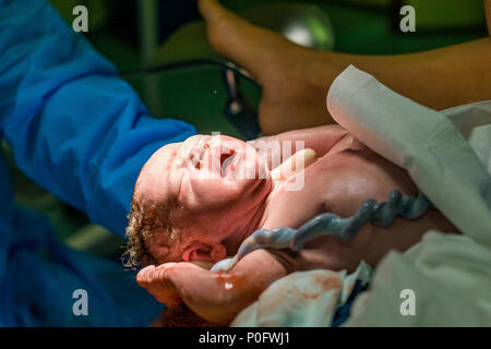 New Born Baby Boy avec cordon ombilical avec l'aide de sage-femme Banque D'Images