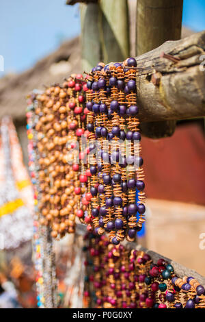 Colliers en perles d'Afrique belle pendu à une poutre en bois dans un marché en plein air Banque D'Images