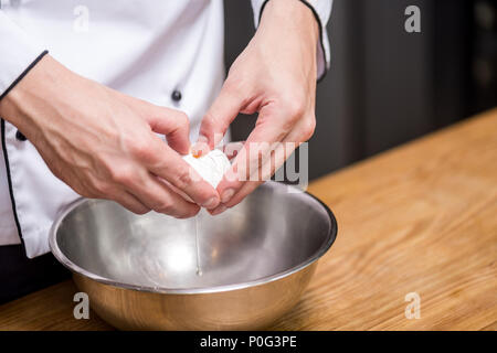 Portrait du chef putting oeuf dans bol Banque D'Images