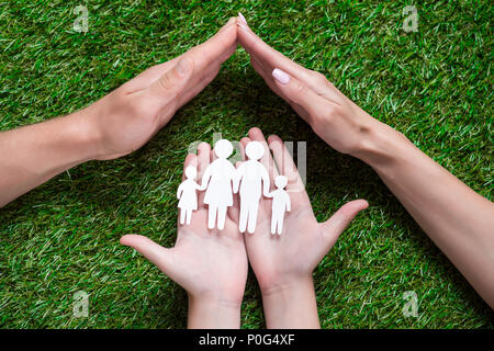 À la vue de mains humaines holding paper cut de famille Banque D'Images