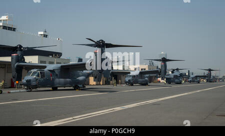 Les commandos de l'air affecté au 353e groupe d'opérations spéciales 1 Détachement décharger cinq CV-22 Osprey avion à rotors basculants déployés à partir du 8e Escadron d'opérations spéciales au nord de Yokohama, Japon, Dock 4 Avril, 2018. Environ 100 aviateurs et cinq Ospreys déployés à Yokota Air Base à participer à des opérations régionales. L'Osprey combine l'atterrissage et décollage vertical, qualités de vol stationnaire d'un hélicoptère avec la longue portée, vitesse et faible consommation de carburant caractéristiques d'un aéronef à turbopropulseur. (U.S. Photo de l'Armée de l'air par la Haute Airman Joseph Pick) Banque D'Images