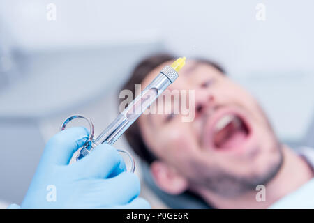 Cropped shot de dentiste holding seringue dentaire dans la main en bureau de dentiste Banque D'Images