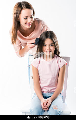 Smiling Mother combing filles cheveux isolé sur fond blanc Banque D'Images