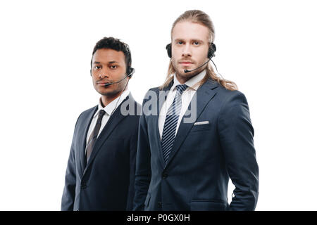 Centre d'appels multi-ethnique grave operators with headsets, isolated on white Banque D'Images