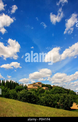 Maison entourée d'arbres dans le Val d'Orcia, Toscane, Italie. En 2004, le Val d'Orcia a été ajouté à la liste du patrimoine mondial de l'UNESCO Banque D'Images