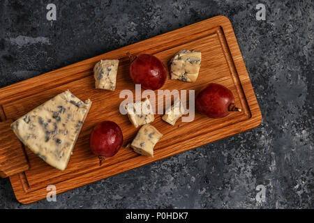 Morceaux de fromage bleu sur sol en bois servant de sélection, vue d'en haut. Banque D'Images