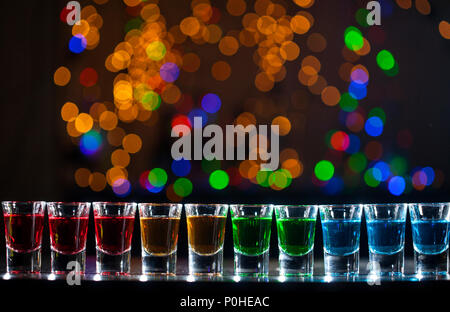 Boisson alcoolisée dans de petits verres sur bar. Cocktails au bar. Photos colorées au club. Boisson alcoolisée en différentes couleurs. Nightlife s Banque D'Images
