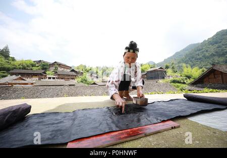 (180609) -- DANZHAI, le 9 juin 2018 (Xinhua) -- Une femme de l'ethnie miao chiffon fait pour rendre les produits de batik à Yangwu Ville de Danzhai County, au sud-ouest de la province du Guizhou, en Chine, le 8 juin 2018. Le peuple Miao artisanat batik est l'un des patrimoines immatériels nationaux de la Chine. Comme le principal site de l'héritage du peuple Miao Miao artisanat batik, la Jijia Village de Yangwu ville a un bon nombre d'excellents artisans, mais le trafic gênant avaient empêché la vente de produits de batik vers l'extérieur avant 2017. Avec l'augmentation de l'amélioration de la circulation et l'aide du gouvernement local et volu Banque D'Images