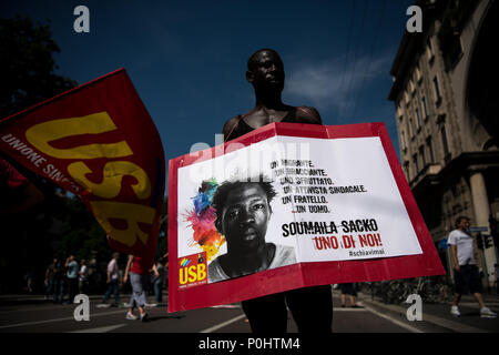 Milan, Italie - 9 juin 2018 : un manifestant tient une pancarte avec la photo de Soumaila Sacko, un Malien de 29 ans travailleur agricole migrant, tué dans une fusillade dimanche dernier dans le village de San Ferdinando dans le sud de la région italienne de Calabre. Banque D'Images