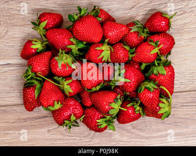 Rouge frais fraise mûre en tas sur fond de bois rustique Banque D'Images