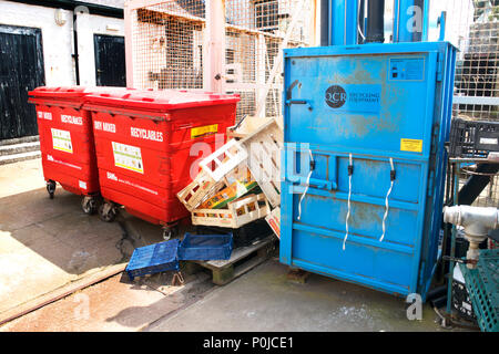 Concasseur de carton et industriels wheelie bins in un chantier de recyclage - John Gollop Banque D'Images