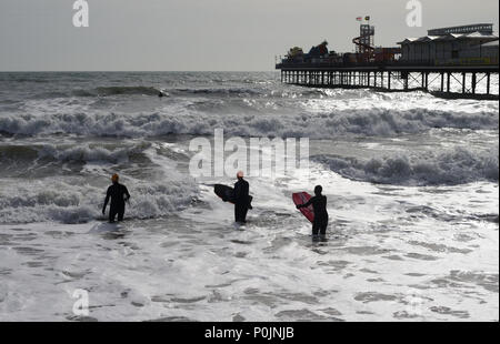 Les surfeurs à côté de Paignton pier. Banque D'Images