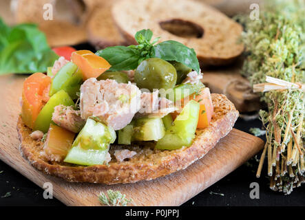 Pain séché alimentaire napolitaine avec de l'huile d'olive, vert et rouge les tomates et le thon appelé fresella Banque D'Images