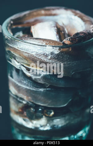 Close up of pile de poisson salé en verre isolé sur fond noir Banque D'Images