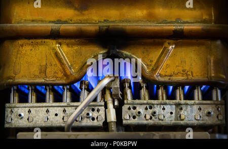 Vue intérieure d'un vieux cuivre gaz chauffe eau à une flamme brûlante Banque D'Images