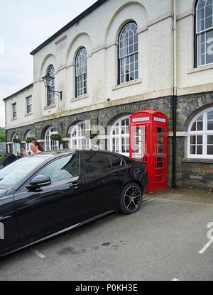 Femme garé sa voiture Jaguar afin de bloquer l'accès d'urgence au village de Hawkshead défibrillateur en Cumbria, le Parc National de Lake District UK GO Banque D'Images