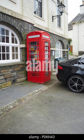 Femme garé sa voiture Jaguar afin de bloquer l'accès d'urgence au village de Hawkshead défibrillateur en Cumbria, le Parc National de Lake District UK GO Banque D'Images