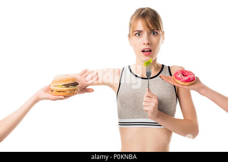 Jeune femme slim refusant de la malbouffe et de manger le brocoli isolated on white Banque D'Images