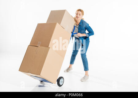 Jeune femme tenant panier chariot chargé avec des cases isolated on white Banque D'Images
