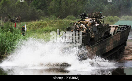 Les soldats britanniques dans un chacal 2A Weapon-Mounted la mobilité, Kit d'installation, sont transportés à travers un danger de l'eau par leurs alliés polonais dans un moyen de transport amphibie de l'armée polonaise à l'Bemowo Piskie Zone formation le 5 juin 2018 dans le cadre de leur participation à la grève de sabre 18. Grève 18 Sabre est la huitième édition de l'armée américaine de longue date par l'Europe de la formation coopérative exercice visant à accroître l'interopérabilité entre les alliés et les partenaires régionaux. (Michigan Army National Guard photo de la CPS. Robert Douglas/publié.) Banque D'Images