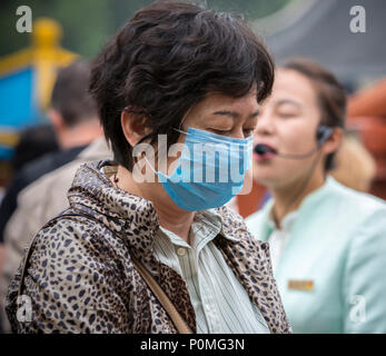 Yangzhou, Jiangsu, Chine. Femme d'âge moyen portant un masque respiratoire. Slender West Lake Park. Banque D'Images