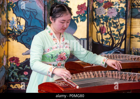 Yangzhou, Jiangsu, Chine. Jeune femme jouant du guzheng, mince West Lake Park. Banque D'Images