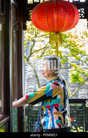 Yangzhou, Jiangsu, Chine. Woman Admiring Cour de la famille Ho Maison et jardin. Banque D'Images