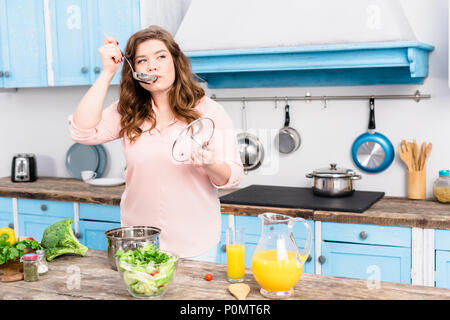 Portrait de jeune femme en surpoids cuisson de la soupe dans la cuisine à la maison Banque D'Images