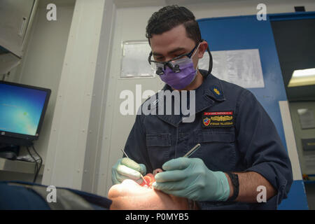 (Océan Pacifique) 1 juin 2018 - Le Lieutenant Stefano Palazzolo nettoie les dents de l'entretien des 2e classe Administrationman Estevan Rodriguez à bord classe Wasp-navire d'assaut amphibie USS Essex (DG 2) au cours de l'exercice de l'unité de formation composite (COMPTUEX). COMPTUEX est le dernier exercice de pré-déploiement qui certifie l'Essex combiné Groupe amphibie (ARG) et 13e Marine Expeditionary Unit (MEU) capacité à mener des opérations militaires en mer et à terre d'un projet au cours de leur déploiement à venir à l'été 2018. (U.S. Photo par marine Spécialiste de la communication de masse 2e classe Chandler Ha Banque D'Images