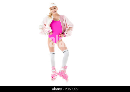 Fille vêtue de rose s'amusant sur patins à isolated on white Banque D'Images