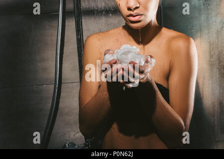 Portrait sur african american woman taking douche avec de la mousse et l'éponge Banque D'Images