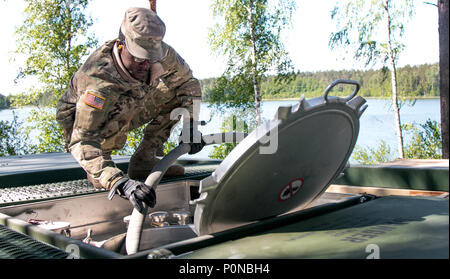 La FPC. William Brown, un spécialiste de l'approvisionnement pétrolier affecté au 226e compagnie d'approvisionnement Composite, 87e Bataillon de soutien de soutien au combat, 3e Division d'infanterie, Fort Stewart, Géorgie, utilise un flexible pour remplir un buffle avec de l'eau purifiée pendant la grève 18 Sabre sur base de Adazi, la Lettonie, le 6 juin 2018. Grève de sabre est un exercice multinational en ce moment à sa huitième année. L'exercice de cette année est prévue pour la période de juin 3-15 et permet aux participants de 19 pays de s'entraîner ensemble et d'améliorer les unités chaque capacité de remplir leurs missions. désignés (U.S. Photo de l'armée Banque D'Images