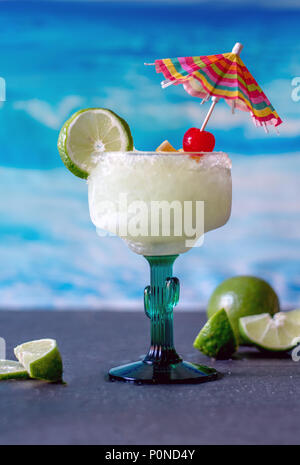 Delicious frozen margarita boissons avec de la chaux et garnir de cerises et un parapluie coloré verre Banque D'Images